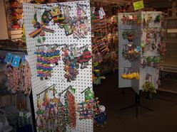 Colorful bird toys displayed on pegboards in a pet store. The vibrant assortment includes various types and shapes, highlighting options for bird enrichment.