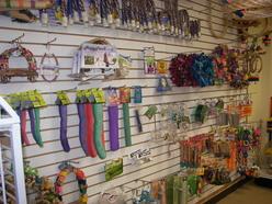Colorful pet toys and accessories displayed on a wall rack in a retail store, showcasing a variety of items for pet owners to choose from.